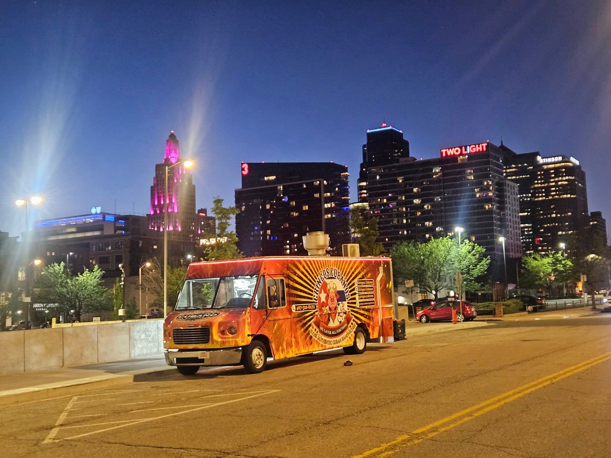 Gringos Cubanos food truck on the curb with downtown towers